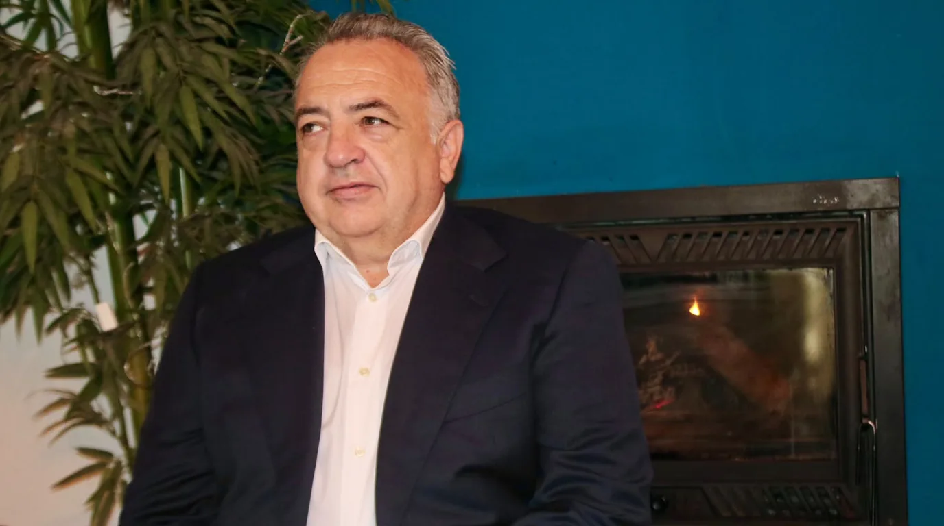 Emilio Corral Romera sentado junto a la chimenea, preparado para una conversación tranquila