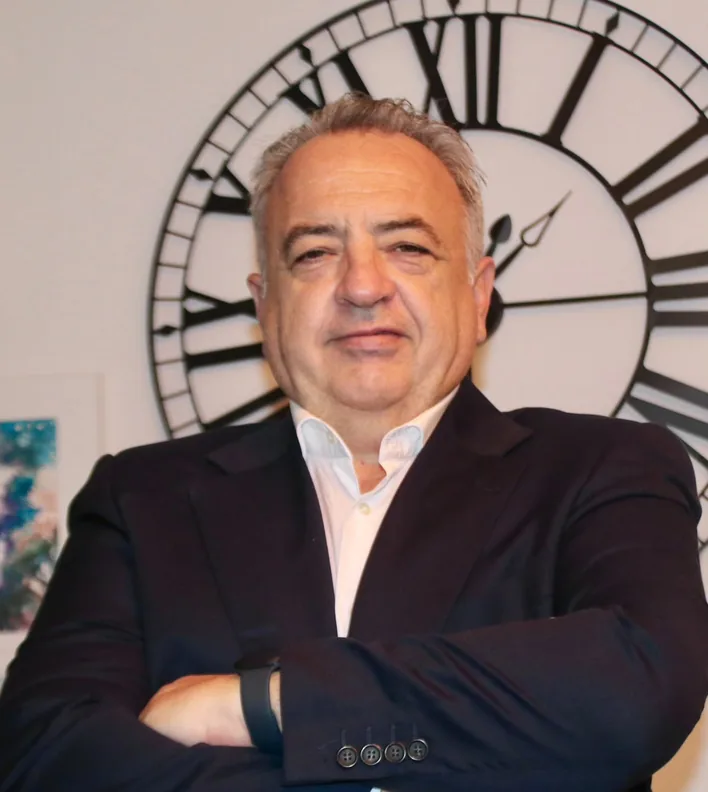 Emilio Corral Romera in a suit, arms crossed, in his office
